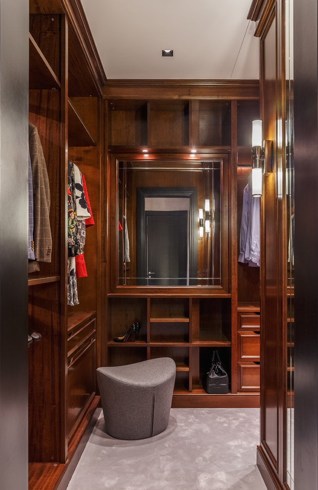 Inspiration for a mid-sized transitional gender-neutral dressing room in Moscow with open cabinets, medium wood cabinets, carpet and grey floor.
