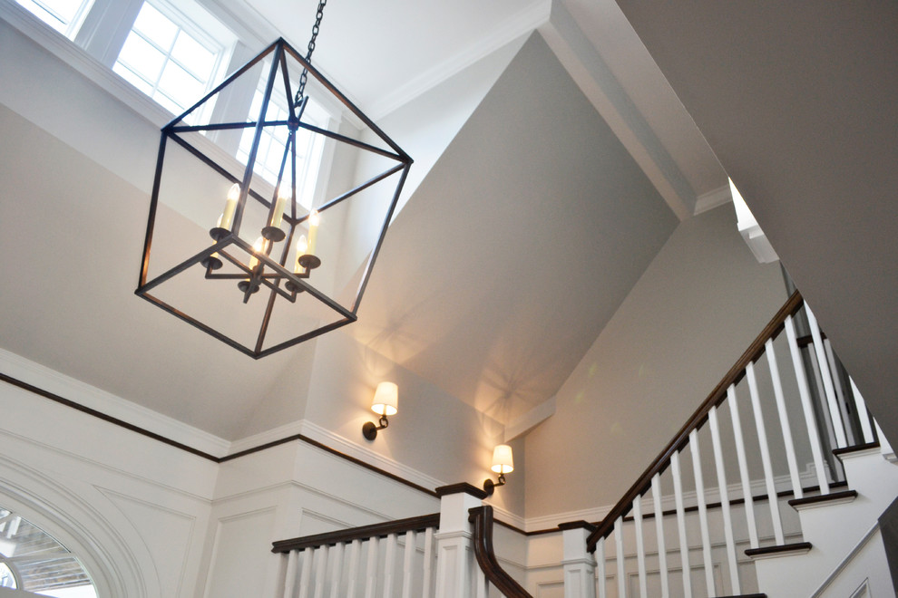 This is an example of a traditional foyer in New York with white walls and dark hardwood floors.