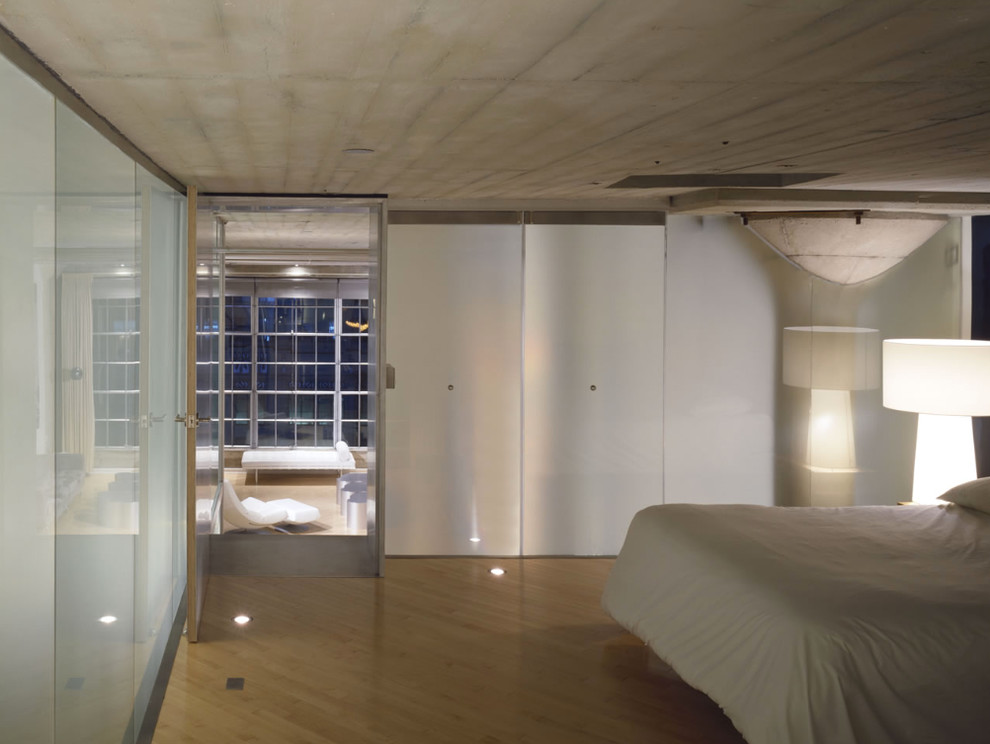 Idee per una camera matrimoniale design di medie dimensioni con pareti bianche e parquet chiaro