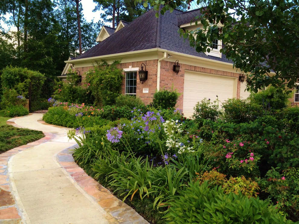 Design ideas for a large mediterranean front yard full sun formal garden for spring in Houston with a garden path and natural stone pavers.