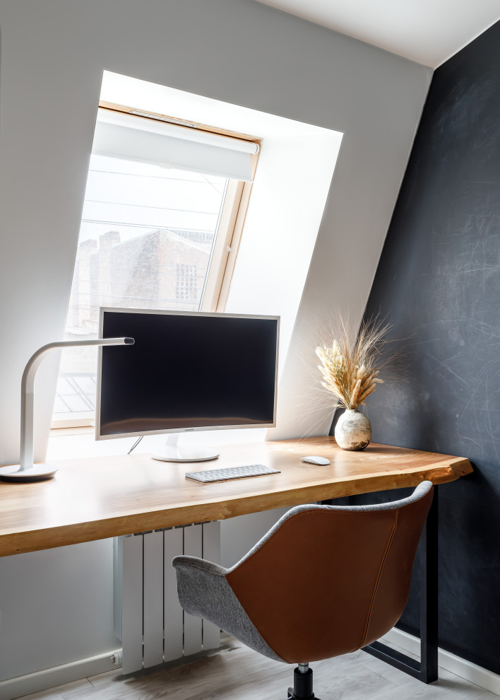 Modelo de despacho nórdico pequeño con paredes blancas, suelo de madera clara, escritorio independiente y suelo beige