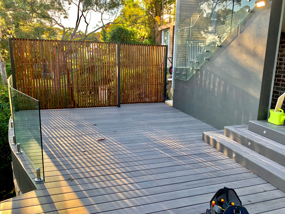 Idee per una grande privacy sulla terrazza minimalista dietro casa e a piano terra con nessuna copertura e parapetto in materiali misti