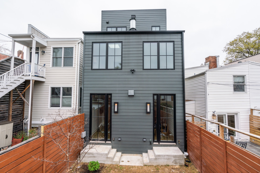 Foto de fachada de casa gris y negra actual extra grande de tres plantas con revestimientos combinados y tejado de metal