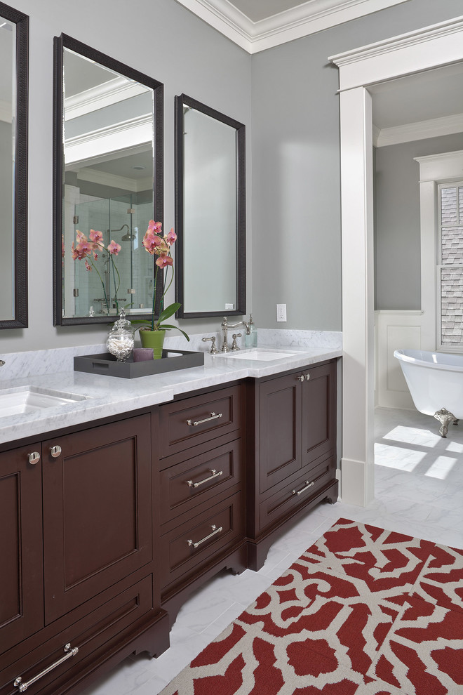 Photo of a traditional bathroom in Houston with an undermount sink, dark wood cabinets, a claw-foot tub, grey walls and recessed-panel cabinets.