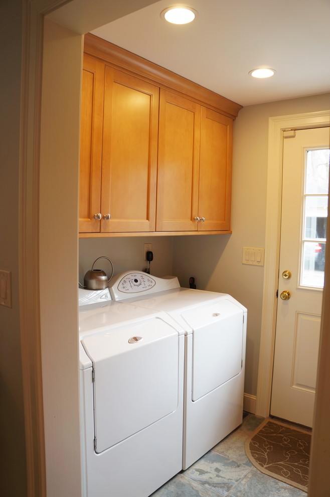 Transitional galley ceramic tile laundry room photo in Boston with shaker cabinets, medium tone wood cabinets, quartz countertops and a side-by-side washer/dryer