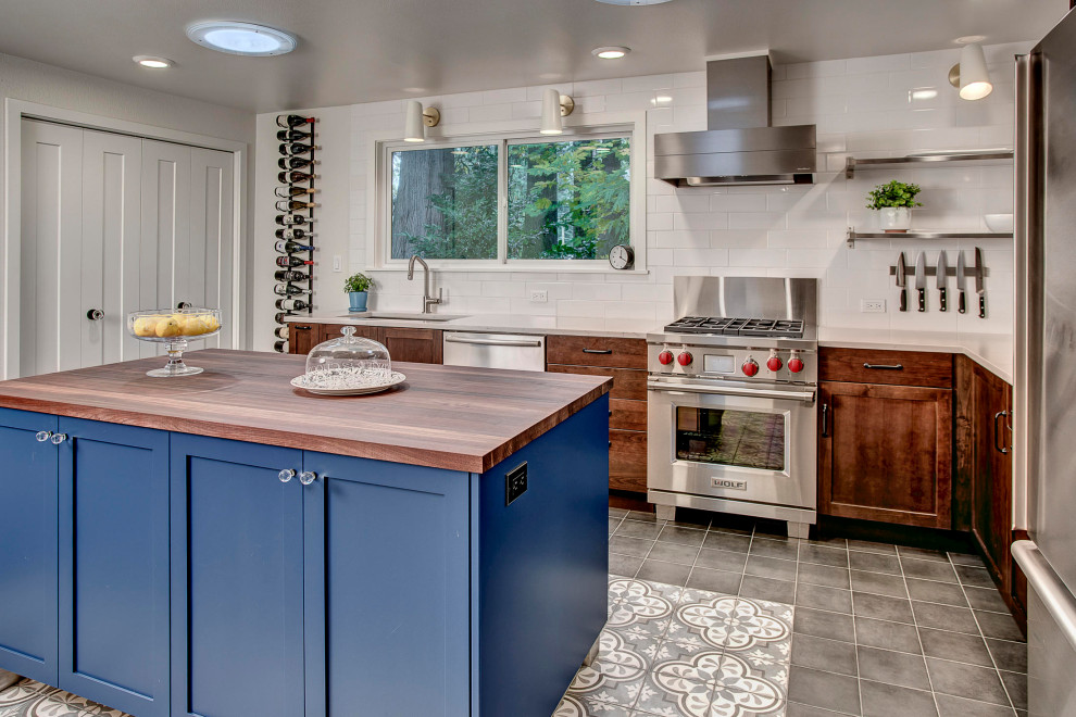 Inspiration for a mid-sized transitional porcelain tile and gray floor eat-in kitchen remodel in Seattle with a single-bowl sink, shaker cabinets, medium tone wood cabinets, wood countertops, white backsplash, porcelain backsplash, stainless steel appliances, an island and brown countertops