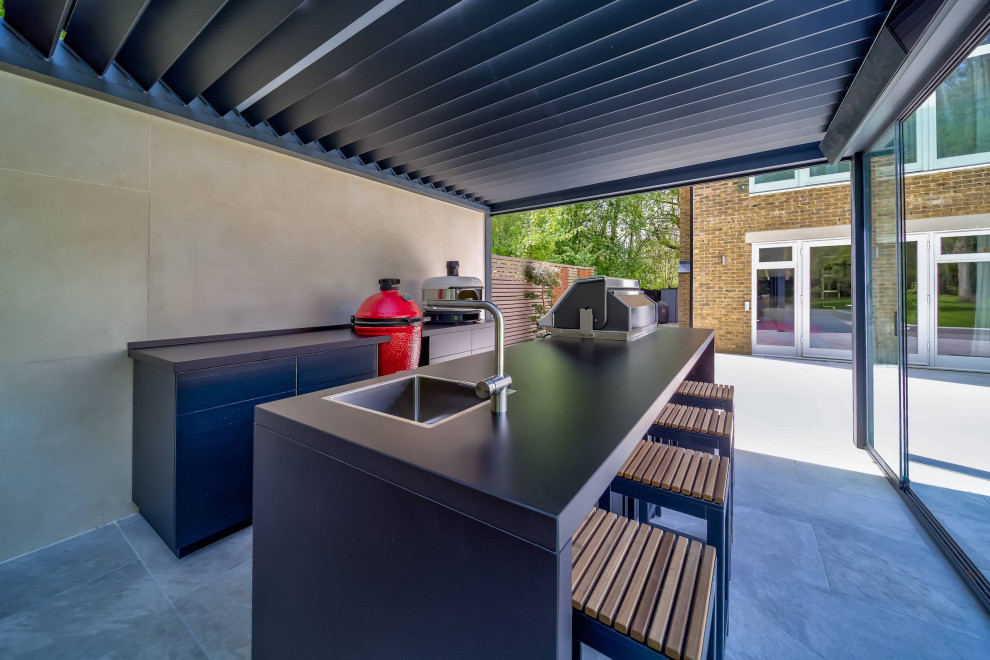 Photo of a contemporary back patio in London with an outdoor kitchen and a pergola.