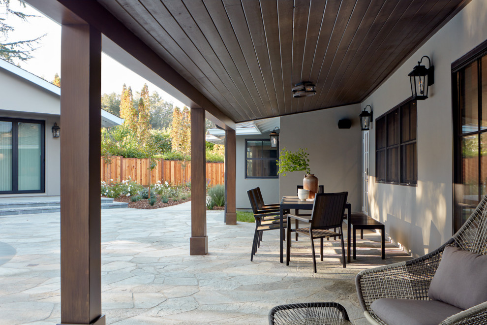 Foto di un patio o portico di medie dimensioni e dietro casa con pavimentazioni in pietra naturale e un tetto a sbalzo