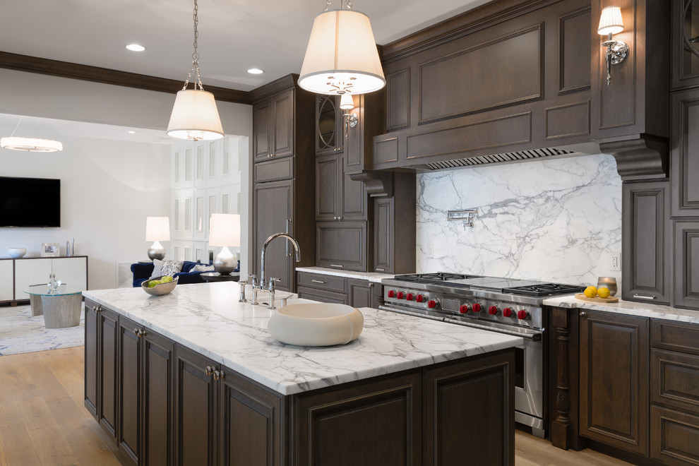 Inspiration for a large transitional single-wall light wood floor and beige floor enclosed kitchen remodel in Tampa with a farmhouse sink, raised-panel cabinets, dark wood cabinets, marble countertops, white backsplash, marble backsplash, stainless steel appliances and an island