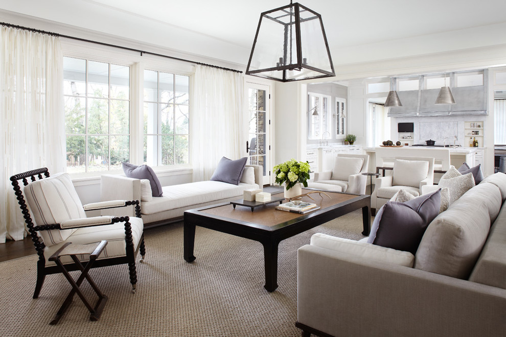 This is an example of a transitional open concept family room in Chicago with white walls and carpet.