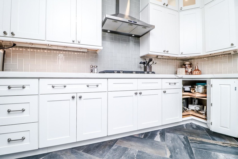 Mid-sized transitional u-shaped separate kitchen in Las Vegas with an undermount sink, shaker cabinets, white cabinets, quartzite benchtops, grey splashback, porcelain splashback, stainless steel appliances, porcelain floors, a peninsula, grey floor and white benchtop.