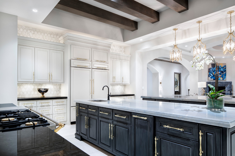 Photo of a transitional l-shaped eat-in kitchen in Austin with an undermount sink, raised-panel cabinets, black cabinets, white splashback, multiple islands and white benchtop.