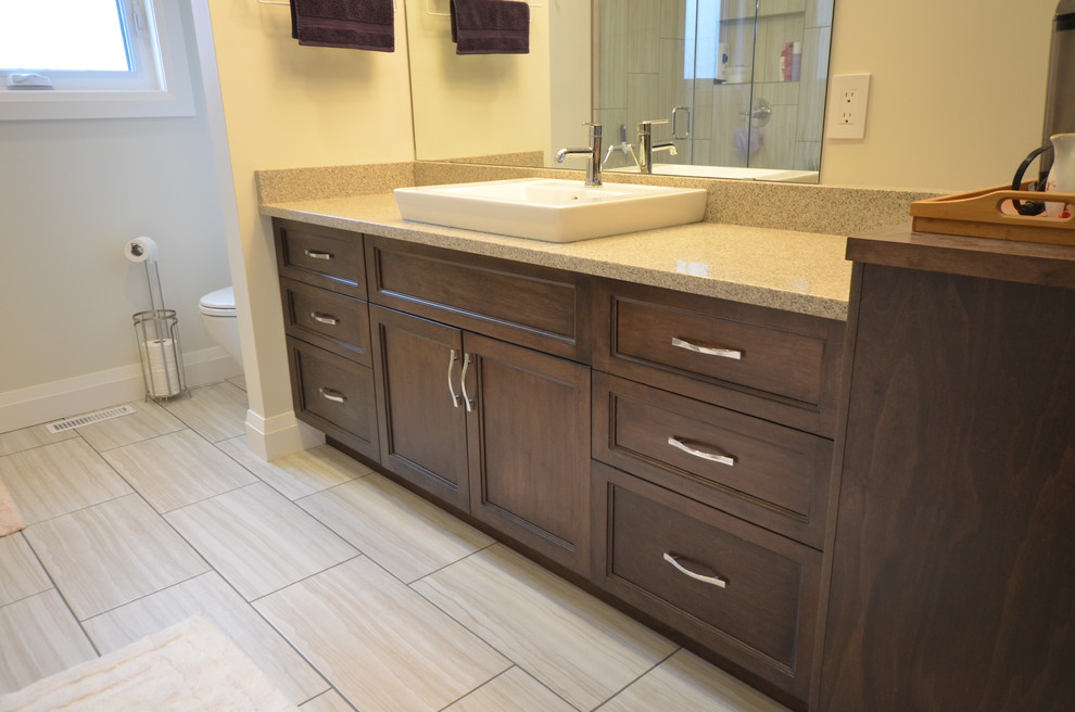 Large transitional master bathroom in Other with a vessel sink, shaker cabinets, medium wood cabinets, quartzite benchtops, a freestanding tub, a corner shower, a two-piece toilet, brown tile, pebble tile and beige walls.