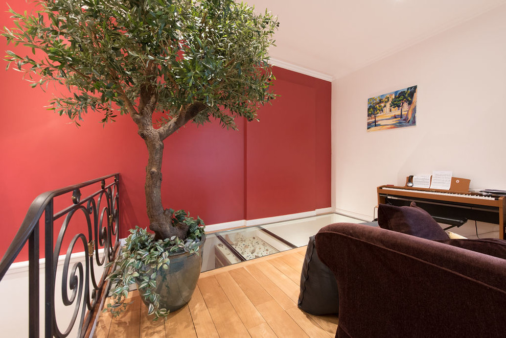 パリにある高級な中くらいなコンテンポラリースタイルのおしゃれなホームオフィス・書斎 (ライブラリー、赤い壁、淡色無垢フローリング、ベージュの床) の写真