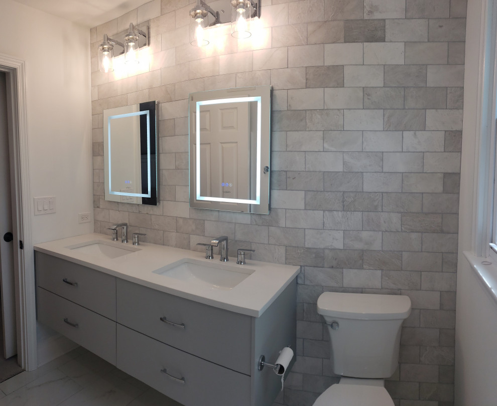 This is an example of a medium sized contemporary ensuite bathroom in Chicago with flat-panel cabinets, grey cabinets, porcelain flooring, engineered stone worktops, white worktops, double sinks and a floating vanity unit.