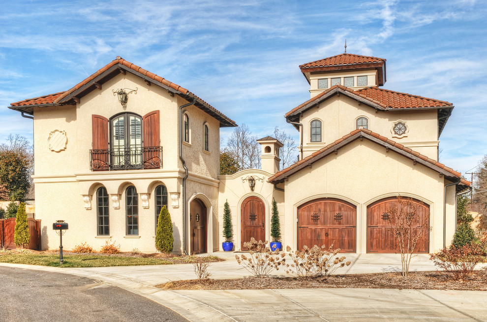 Large mediterranean three-storey stucco white exterior in Charlotte with a gable roof.