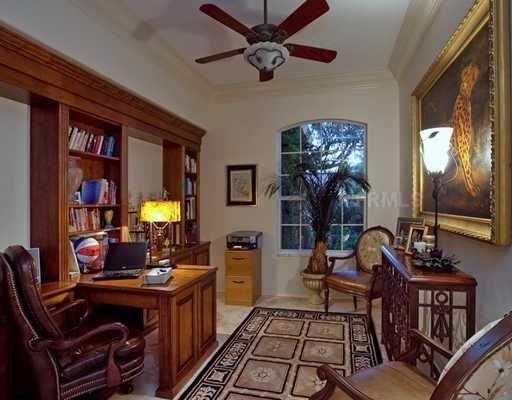 Small elegant built-in desk travertine floor home office photo in Tampa with beige walls