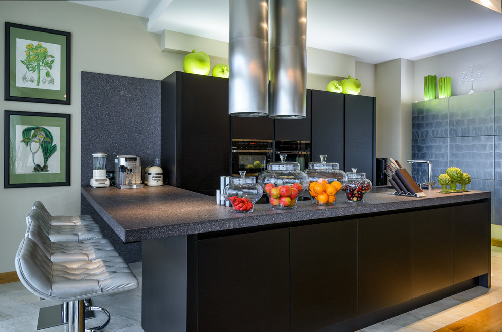 This is an example of a contemporary kitchen in Moscow with flat-panel cabinets, black cabinets, black appliances and a peninsula.