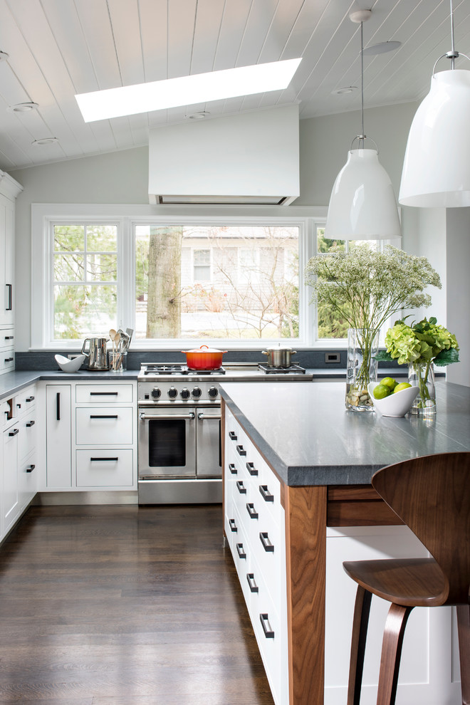 Photo of a large transitional l-shaped eat-in kitchen in New York with a single-bowl sink, shaker cabinets, white cabinets, limestone benchtops, grey splashback, stone slab splashback, stainless steel appliances, medium hardwood floors and with island.
