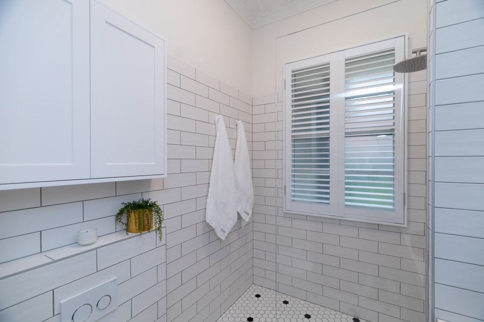 Inspiration for a small contemporary 3/4 bathroom in Sydney with a curbless shower, white tile, porcelain tile, white walls, porcelain floors, tile benchtops, white floor, a shower seat and a single vanity.