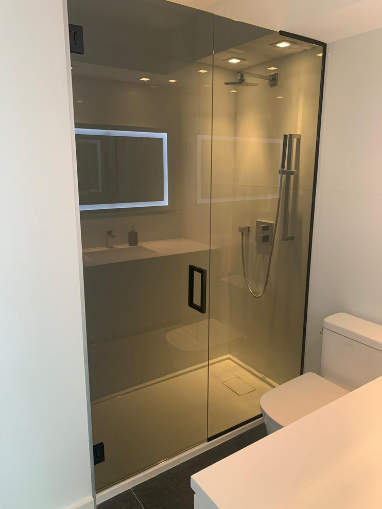Small modern 3/4 bathroom in Miami with glass-front cabinets, white cabinets, an open shower, a one-piece toilet, white tile, ceramic tile, white walls, ceramic floors, a drop-in sink, quartzite benchtops, black floor, a sliding shower screen, white benchtops, a single vanity and a built-in vanity.