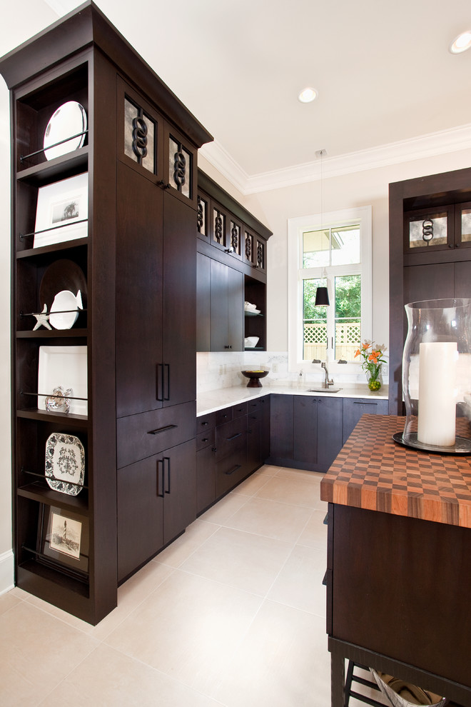 Photo of a transitional kitchen in Miami with flat-panel cabinets, dark wood cabinets, white splashback and with island.