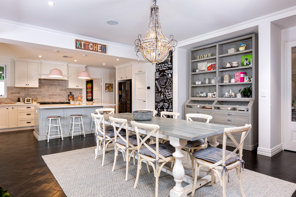 Ispirazione per una sala da pranzo aperta verso la cucina stile marinaro di medie dimensioni con pareti bianche, parquet scuro e pavimento marrone