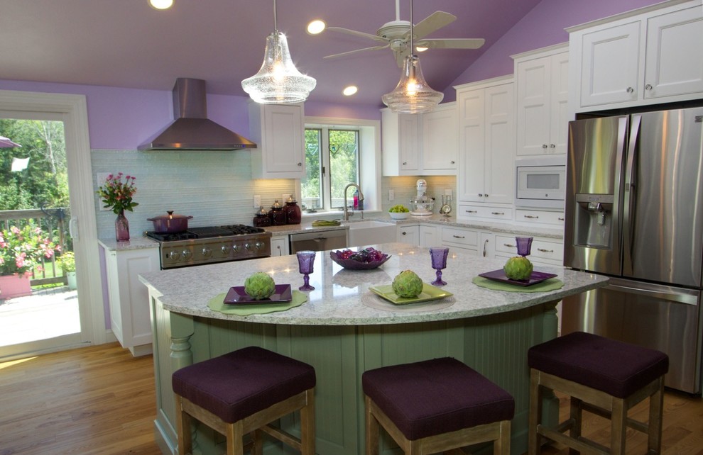 Foto på ett mellanstort lantligt kök, med en rustik diskho, skåp i shakerstil, vita skåp, granitbänkskiva, grönt stänkskydd, stänkskydd i glaskakel, rostfria vitvaror, ljust trägolv och en halv köksö