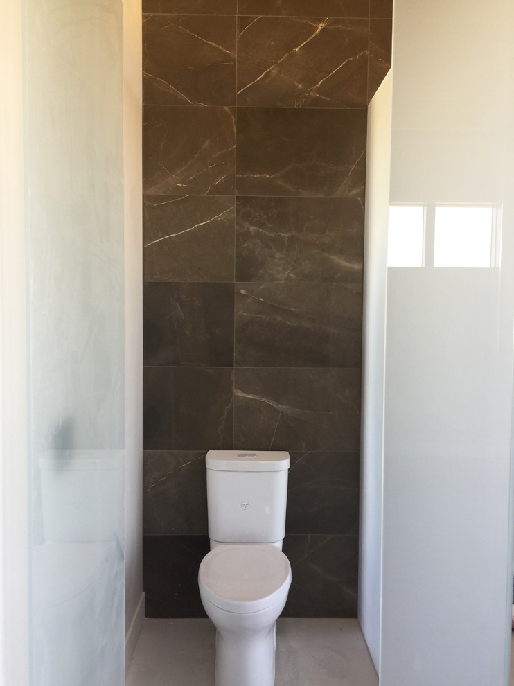 Design ideas for an expansive modern master bathroom in San Francisco with flat-panel cabinets, medium wood cabinets, a freestanding tub, a curbless shower, a one-piece toilet, brown tile, marble, brown walls, porcelain floors, a vessel sink, marble benchtops, beige floor and a hinged shower door.