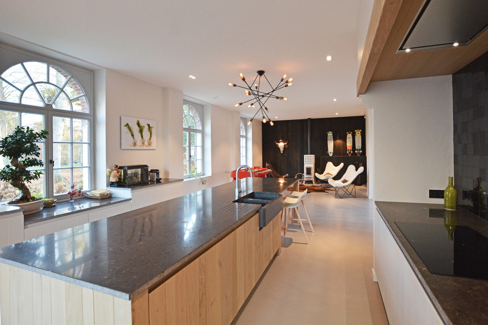 This is an example of a large contemporary galley eat-in kitchen in Paris with beaded inset cabinets, light wood cabinets and with island.