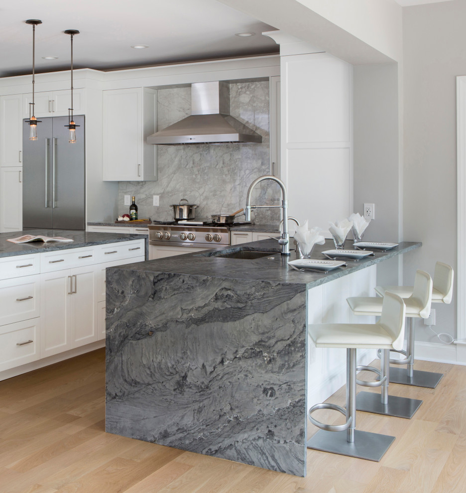 Inspiration for a large transitional kitchen in Philadelphia with an undermount sink, shaker cabinets, white cabinets, quartzite benchtops, grey splashback, porcelain splashback, stainless steel appliances, light hardwood floors, with island, beige floor and grey benchtop.