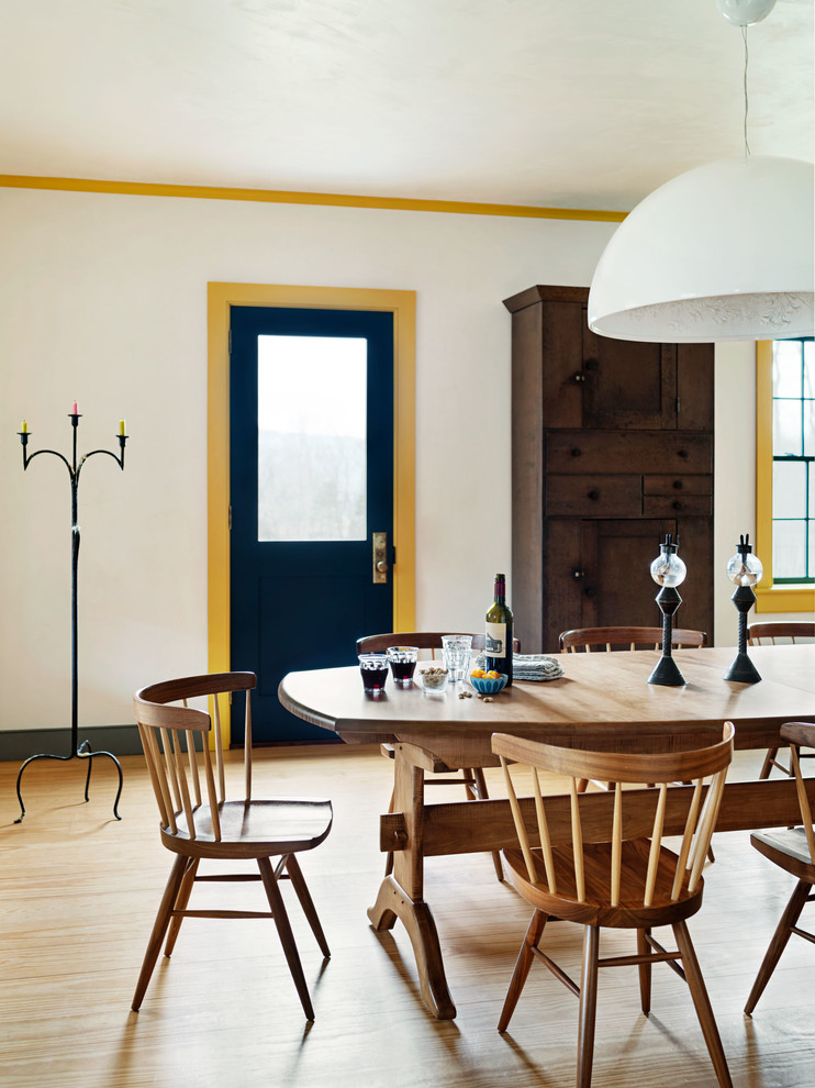 Design ideas for a country dining room in New York with white walls and light hardwood floors.