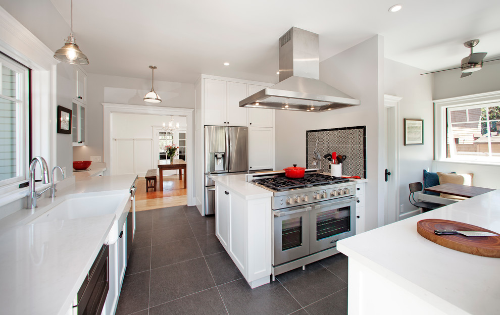 Enclosed kitchen - large transitional u-shaped porcelain tile and gray floor enclosed kitchen idea with a farmhouse sink, shaker cabinets, white cabinets, quartz countertops, multicolored backsplash, ceramic backsplash, stainless steel appliances, a peninsula and white countertops