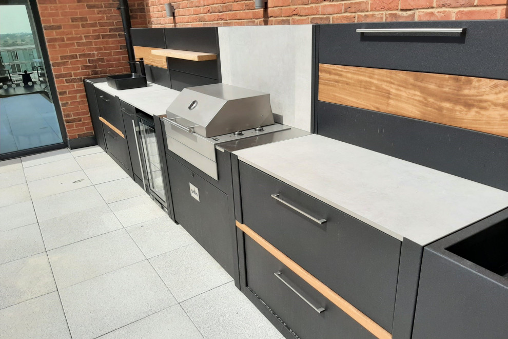 Cette image montre un toit terrasse sur le toit design de taille moyenne avec une cuisine d'été, aucune couverture et un garde-corps en métal.