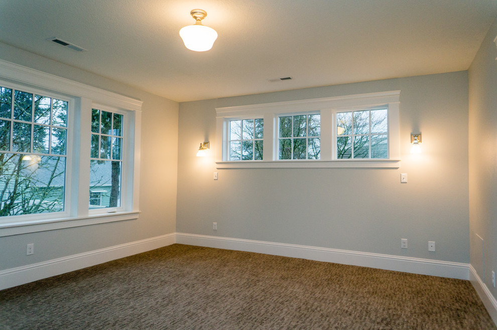 This is an example of a mid-sized arts and crafts master bedroom in Portland with carpet.
