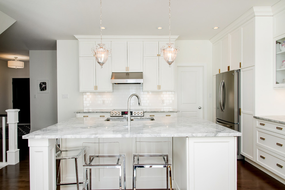 Mid-sized transitional single-wall dark wood floor and brown floor eat-in kitchen photo with an undermount sink, quartzite countertops, white backsplash, subway tile backsplash, stainless steel appliances, an island, recessed-panel cabinets and white cabinets