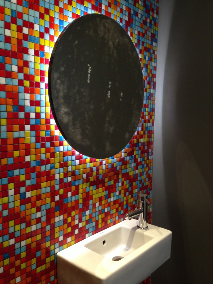 This is an example of a small modern powder room in Sydney with a one-piece toilet, mosaic tile, porcelain floors, a wall-mount sink, multi-coloured walls and multi-coloured tile.