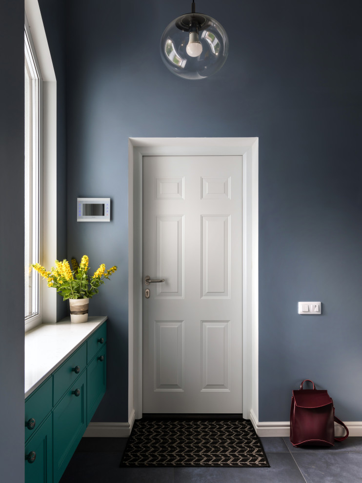 Cette image montre une porte d'entrée bohème de taille moyenne avec un mur gris, un sol en carrelage de porcelaine, une porte simple et une porte blanche.