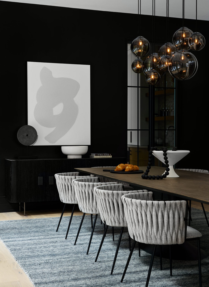 Example of a minimalist light wood floor dining room design in Chicago with black walls and no fireplace