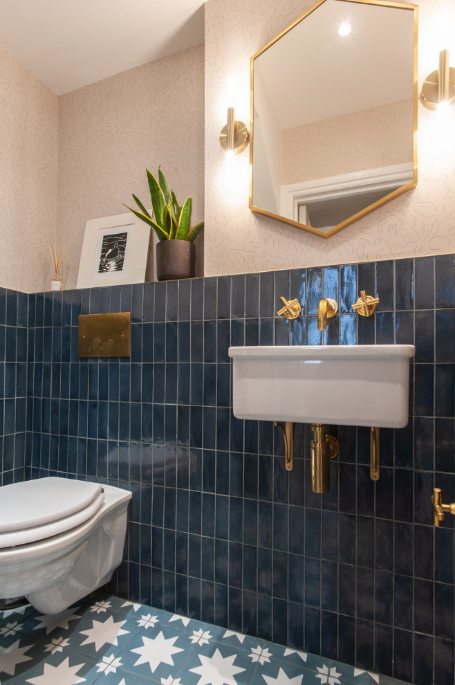 На фото: большой туалет в стиле неоклассика (современная классика) с инсталляцией, синей плиткой, керамической плиткой, полом из керамогранита, подвесной раковиной, синим полом, обоями на стенах и розовыми стенами с