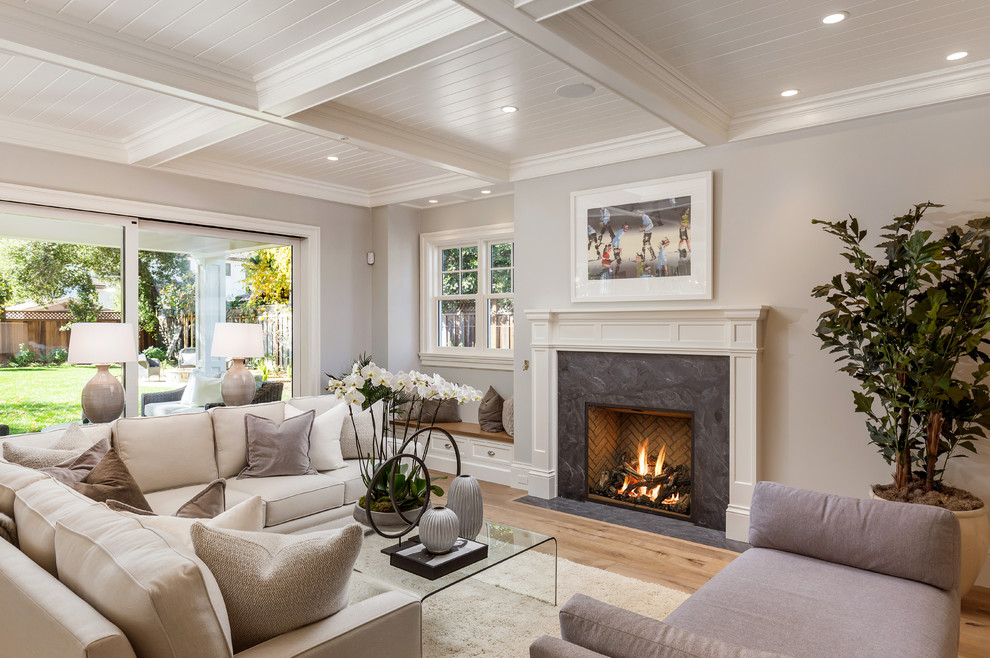 Transitional family room in San Francisco with beige walls, light hardwood floors, a standard fireplace and a stone fireplace surround.