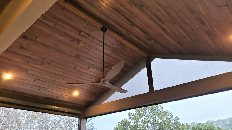 Large mountain style backyard second story metal railing deck photo in Austin with a roof extension