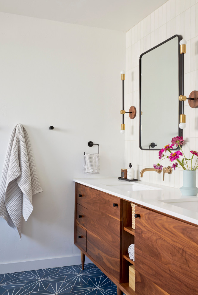Photo of a mid-sized midcentury master bathroom in San Francisco with flat-panel cabinets, brown cabinets, a corner shower, white tile, ceramic tile, white walls, cement tiles, an undermount sink, engineered quartz benchtops, blue floor, a hinged shower door, white benchtops, a shower seat, a double vanity and a freestanding vanity.