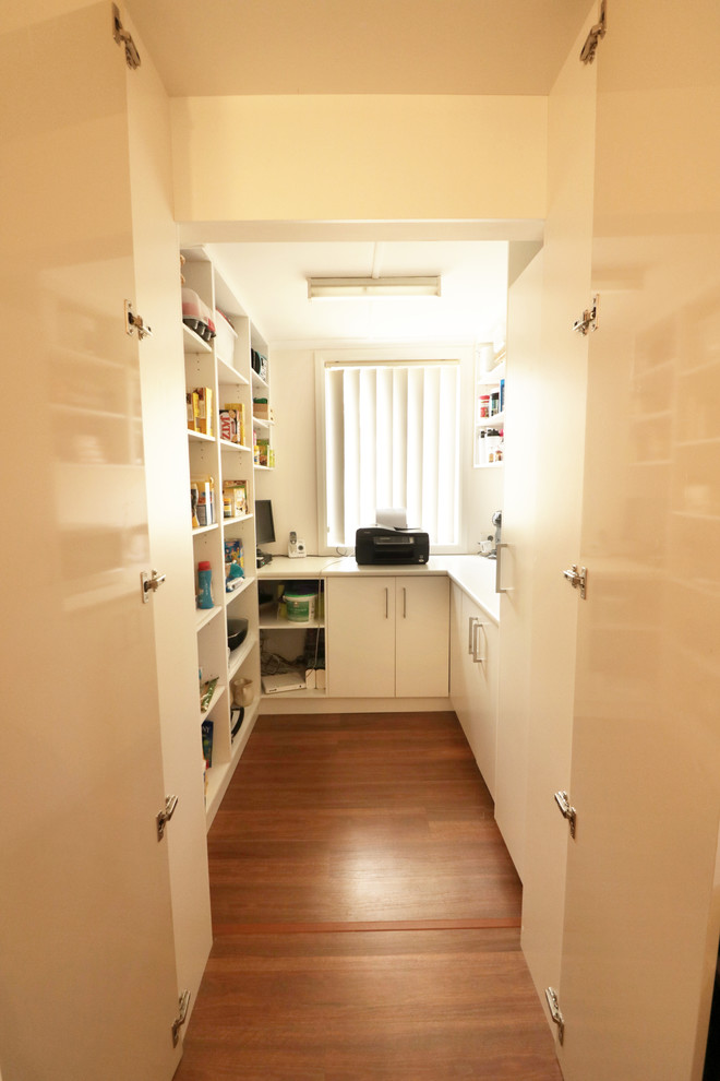 Mid-sized contemporary u-shaped kitchen pantry in Sydney with a drop-in sink, flat-panel cabinets, beige cabinets, quartz benchtops, brown splashback, glass sheet splashback, stainless steel appliances, light hardwood floors, with island and yellow floor.