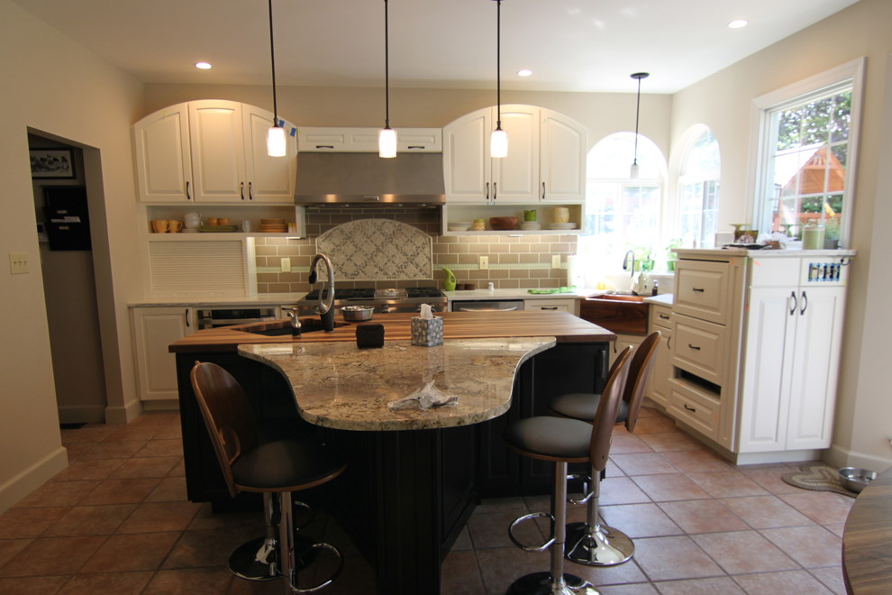 Example of a mid-sized transitional l-shaped terra-cotta tile and brown floor eat-in kitchen design in Miami with a farmhouse sink, raised-panel cabinets, white cabinets, granite countertops, brown backsplash, subway tile backsplash and an island