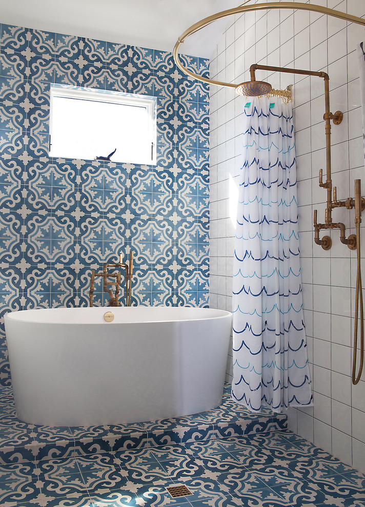 Country bathroom in Los Angeles with a freestanding tub, an open shower, blue tile, multi-coloured tile, white tile and a shower curtain.