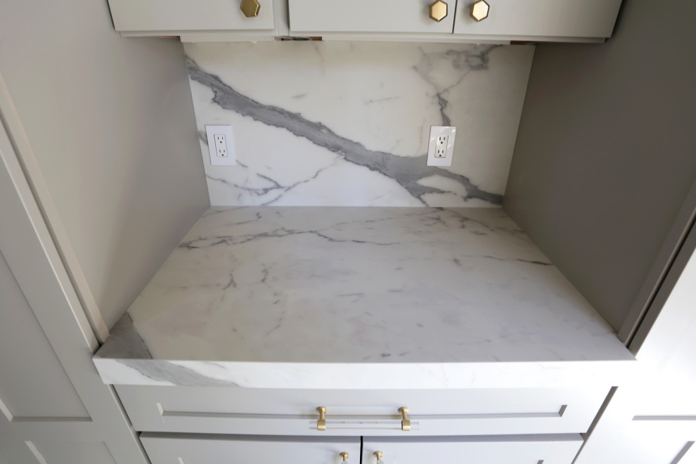 Example of a mid-sized transitional l-shaped marble floor, white floor and exposed beam kitchen design in DC Metro with an undermount sink, shaker cabinets, white cabinets, quartzite countertops, white backsplash, quartz backsplash and stainless steel appliances