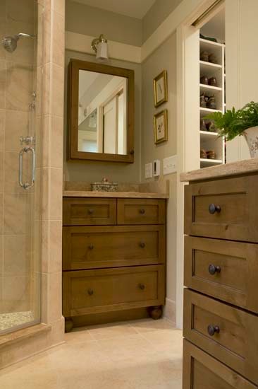 Inspiration for a traditional bathroom in DC Metro with an undermount sink, furniture-like cabinets, medium wood cabinets, marble benchtops, an undermount tub, a corner shower, a wall-mount toilet, beige tile and stone tile.