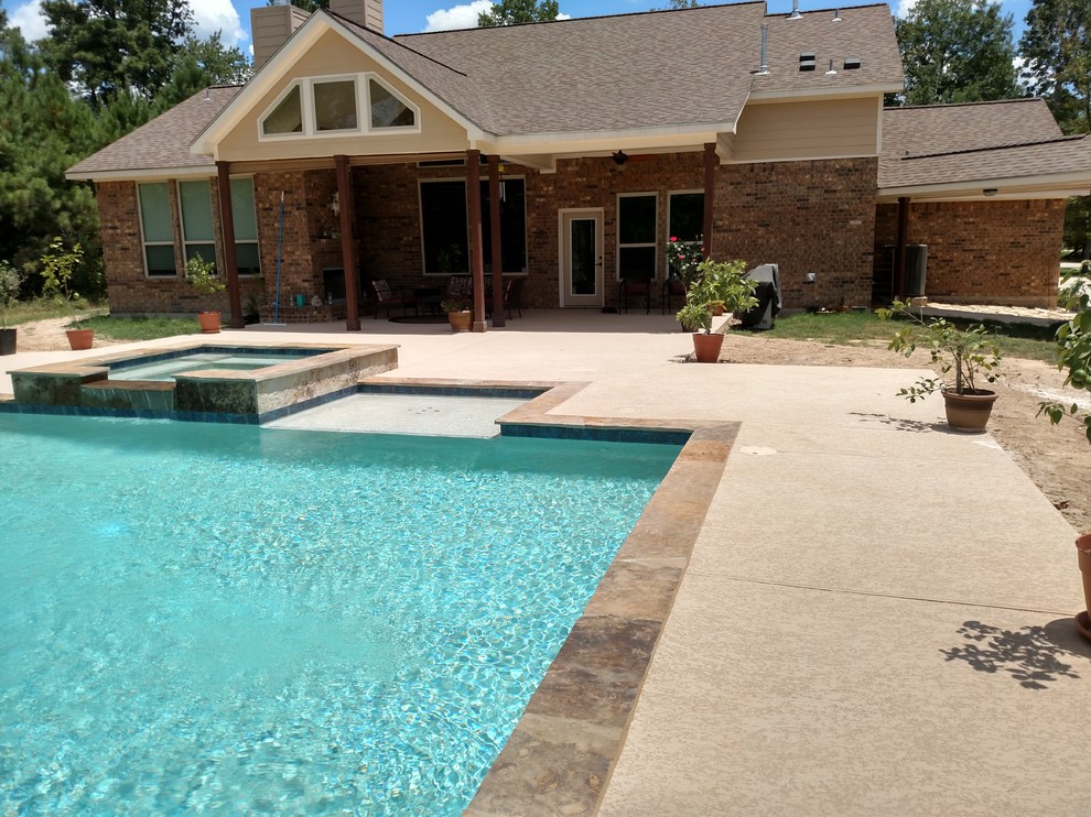 Mid-sized traditional backyard rectangular pool in Houston with a hot tub and concrete slab.