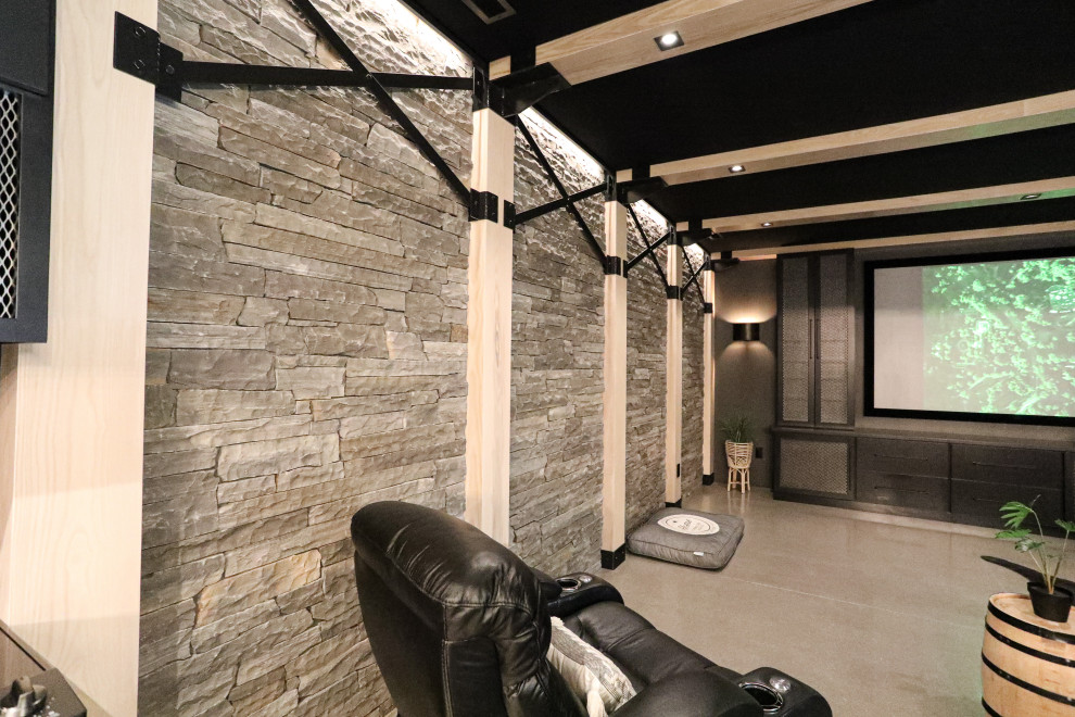 This is an example of a large industrial basement in Other with a home cinema, black walls, concrete flooring and grey floors.